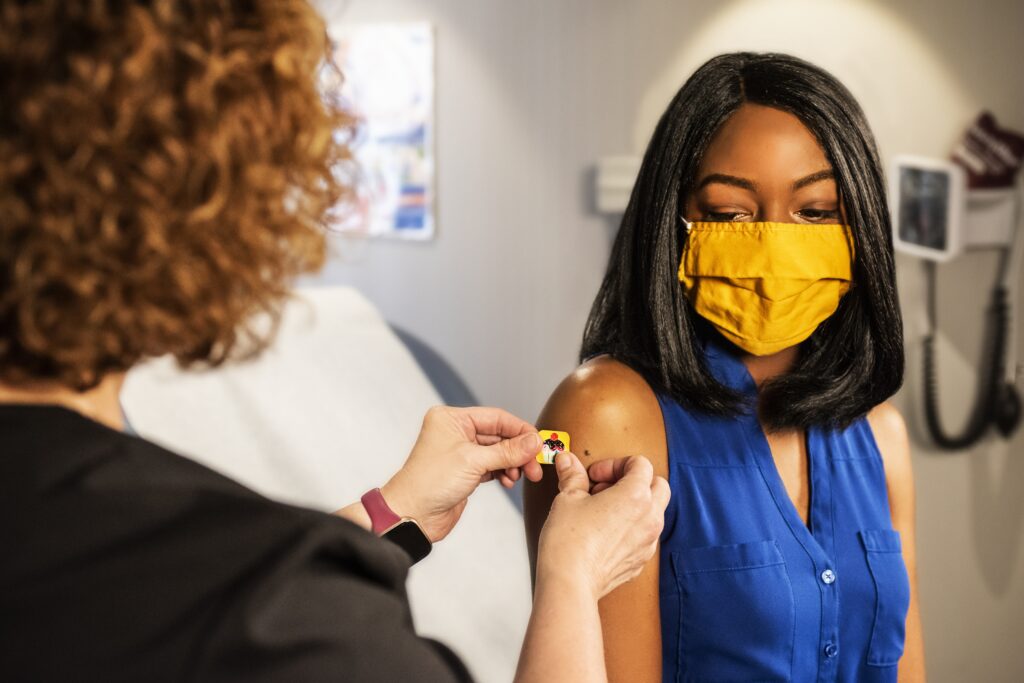 Vaccine given in shoulder of a black woman