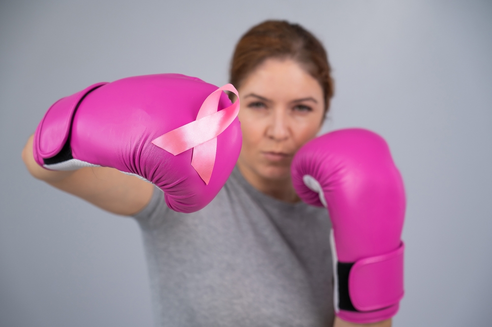 Beat cancer woman with pink gloves and pink ribbon for breast cancer